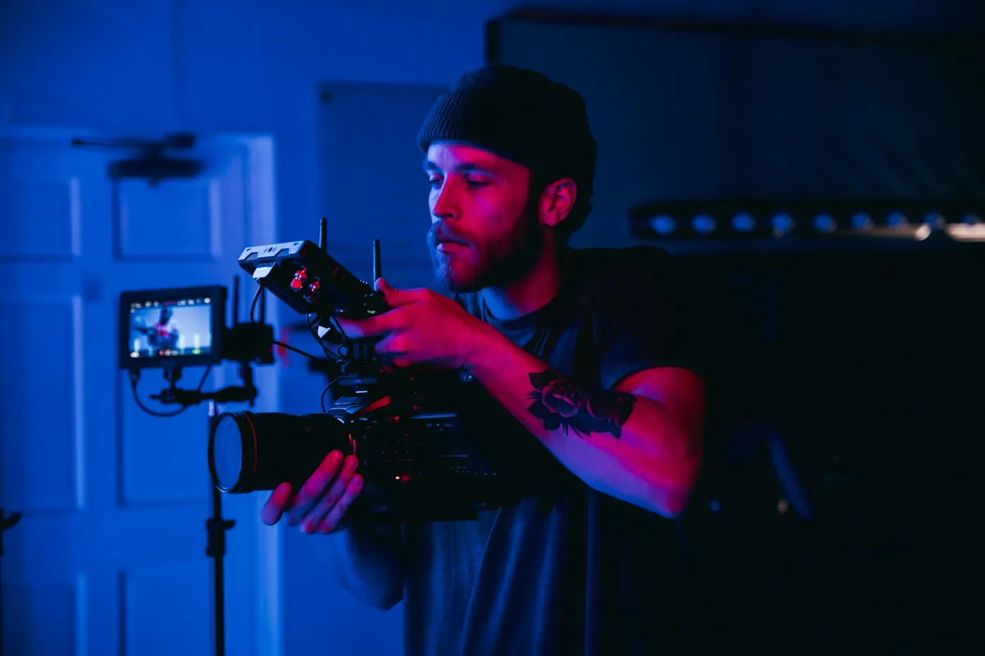 Operador de cámara grabando con una cámara profesional y luz azul de estudio